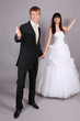 Beautiful bride and groom welcome in studio on gray background