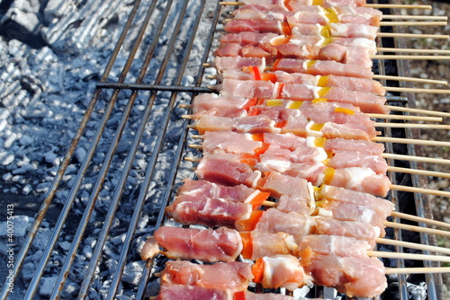 Photo: raw pork kabobs grill on skewers on a barbecue raw pork kabobs grill on skewers on a barbecue