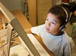 LIttle Boy with Headphones Concentrating at the Computer