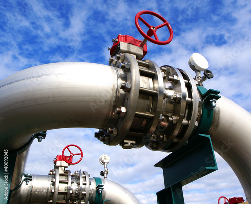 Photo: Industrial zone, Steel pipelines and valves against blue sky Industrial zone, Steel pipelines and valves against blue sky