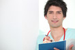 Young doctor writing in notebook