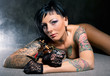 Beautiful woman with many tattoos posing  indoors