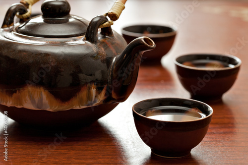 Photo: cup of tea and teapot, wooden desk cup of tea and teapot, wooden desk