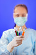 Doctor (woman) analyzing medical test tubes on blue background Doctor (woman) analyzing medical test tubes on blue background
