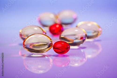 Photo: Pills (capsules) of cod-liver oil on violet, macro view with sel Pills (capsules) of cod-liver oil on violet, macro view with sel