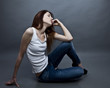 Photo: Young attractive woman siting on the studio floor. Young attractive woman siting on the studio floor.