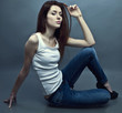 Photo: Young attractive woman siting on the studio floor. Young attractive woman siting on the studio floor.