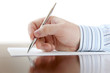 Closeup of a business man's hand with pen on the desk Closeup of a business man's hand with pen on the desk
