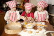 Three little chefs enjoying in the kitchen making big mess. Litt