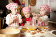 Foto: Three little chefs enjoying in the kitchen making big mess. Litt Three little chefs enjoying in the kitchen making big mess. Litt
