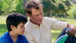 Father and son reading a book aloud