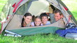 Smiling family lying in a tent