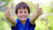 Smiling child placing his thumbs up