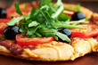 Pizza with tomatoes, olives and arugula