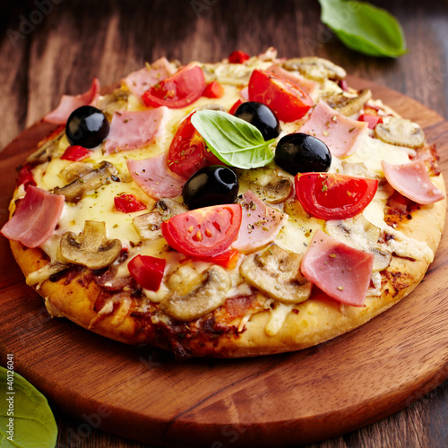 Foto: Pizza with ham, mushrooms and cherry tomatoes Pizza with ham, mushrooms and cherry tomatoes