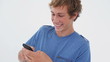 Smiling brunette man texting on his cellphone