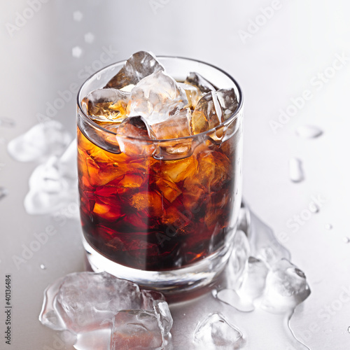 Photo: glass of cola with ice and water droplets glass of cola with ice and water droplets