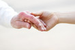 Senior and Young Women Holding Hands