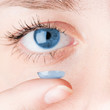Close up of inserting a contact lens in female eye