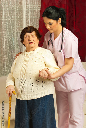 Photo: Nurse helping sick senior home Nurse helping sick senior home