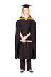 pretty female college graduate in gown and cap on white