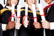 group of multiracial graduates holding certificates