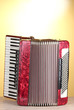 Retro accordion on wooden table on yellow background Retro accordion on wooden table on yellow background