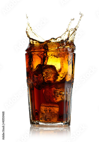 Photo: Splashing cola in glass. Isolated on white background Splashing cola in glass. Isolated on white background