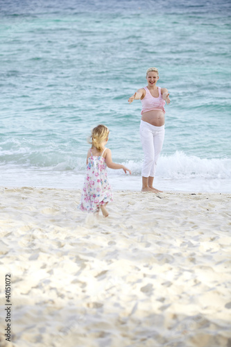 Photo: junge schwangere mutter mit ihrer tochter am strand junge schwangere mutter mit ihrer tochter am strand