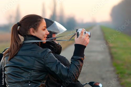 Foto: Young happy couple ready to go on a ride with motorcycle Young happy couple ready to go on a ride with motorcycle