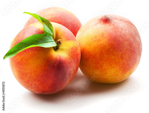 Photo: ripe peach fruits with green leaves isolated on white background ripe peach fruits with green leaves isolated on white background