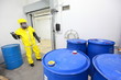 worker in uniform dealing with barrels of toxic substance