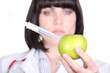 Doctor with a syringe in an apple