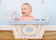 adorable baby boy sitting in blue wicker basket
