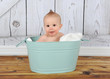 happy baby sitting in washtub