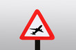 Startendes Flugzeug auf einem Achtung Schild.