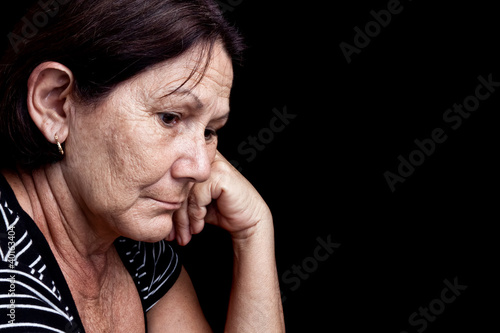 Photo: Sad and worried old woman isolated on black Sad and worried old woman isolated on black