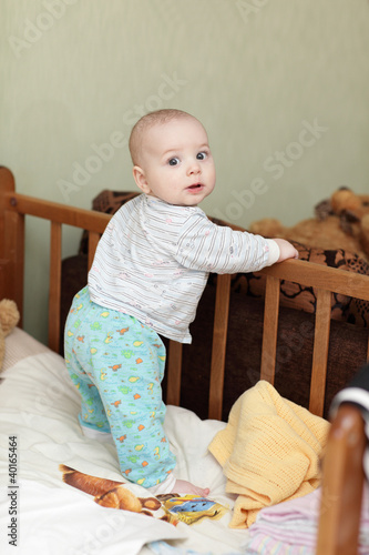 Photo: Baby standing in cot Baby standing in cot