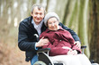 old senior woman in wheelchair with careful son