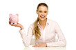 Attractive woman holding piggy bank
