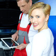 Customer and mechanic in a garage checking car with touchpad