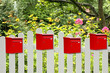 Foto: Rote Briefkästen am Gartenzaun Rote Briefkästen am Gartenzaun