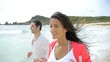 Couple jogging on the beach by the sea