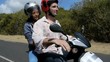 Young people riding motorbike on vacation