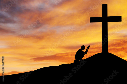 Photo: Man praying under the cross Man praying under the cross