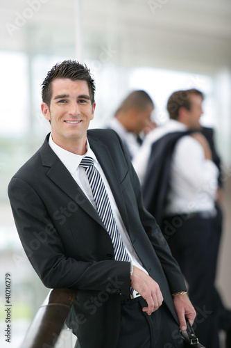 Photo: Smiling banker standing in a hall Smiling banker standing in a hall