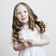 Portrait of a beautiful little girl in a white dress