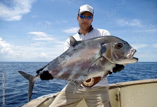 Photo: Happy fisherman holding a trevally jack Happy fisherman holding a trevally jack