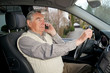 Senior mit Handy beim autofahren