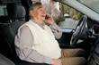 Senior mit Mobiltelefon im Auto